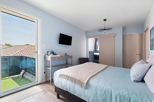 a bedroom with a bed and a sliding glass door at Chambres D'hôtes Authentique Pornic in Pornic