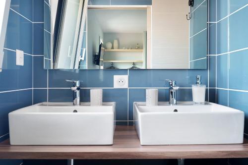 two white sinks in a bathroom with blue tiles at Chambres D'hôtes Authentique Pornic in Pornic