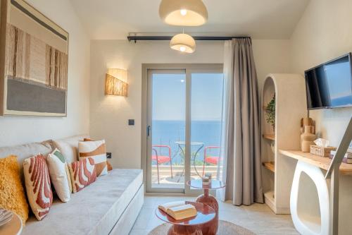 a living room with a couch and a view of the ocean at Soluna Forte Sea Living Suites in Palaiokastro