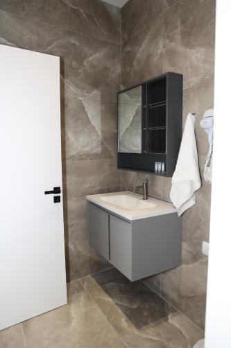 a bathroom with a white sink and a mirror at Vila Gabriel in Shkodër