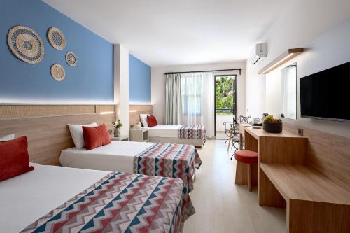 a hotel room with two beds and a flat screen tv at Club Titan Hotel Ultra All Inclusive in Kargicak
