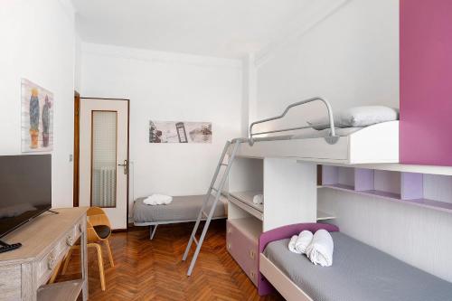 a room with two bunk beds and a desk at La Rosa Blu Vacation Home in Sanremo