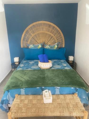 a bedroom with a bed with a blue wall at Villa MYA Location in Saint-Pierre
