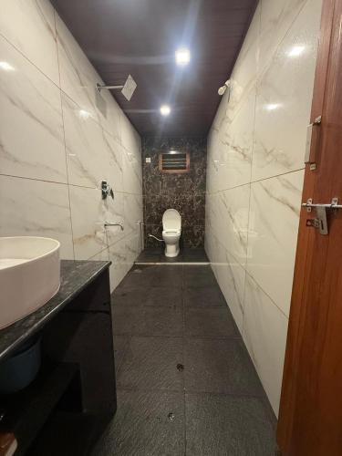 a small bathroom with a toilet and a sink at Ira Homestay in Sringeri