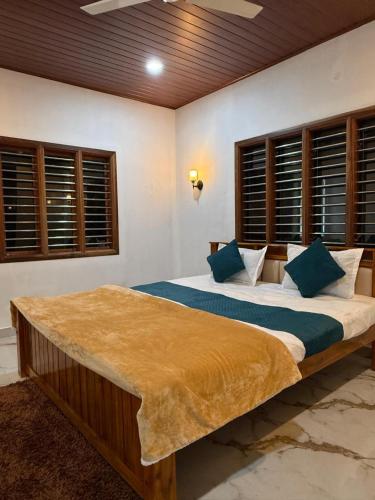 a bedroom with a large bed with blue pillows at Ira Homestay in Sringeri