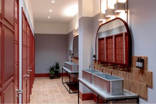 a bathroom with three sinks and a mirror at Bermonds Locke, Tower Bridge in London