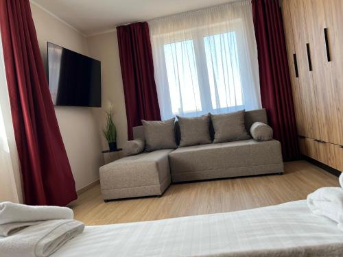 a living room with a couch and red curtains at Kálvária panzió in Tata