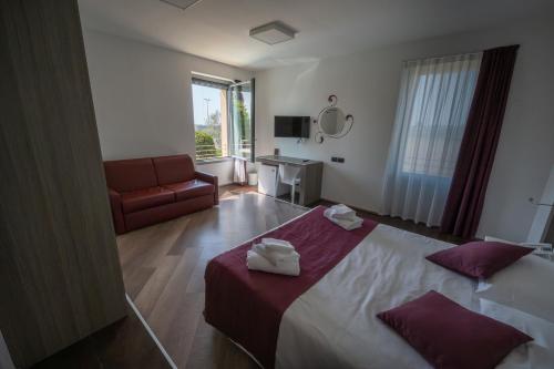 a hotel room with a bed and a couch at Hotel Corte Del Paggio in Valeggio sul Mincio