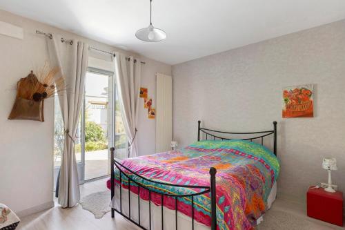 a bedroom with a bed with a colorful comforter at Lacelledort in La Celle-Saint-Avant