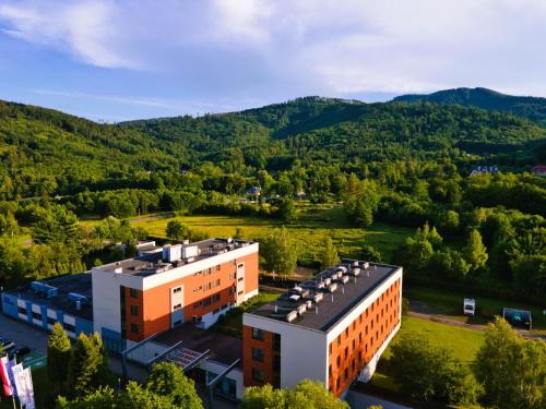 Luftaufnahme eines Gebäudes mit Bergen im Hintergrund in der Unterkunft Hotel Szyndzielnia in Bielsko-Biała
