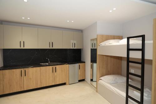 a room with two bunk beds and a kitchen at Vila Gabriel in Shkodër