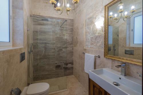 a bathroom with a shower and a toilet and a sink at Valletta Suite Drew in Valletta