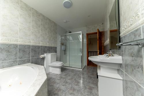 a bathroom with a tub and a toilet and a sink at Stone House , Boyne Valley Views in Donore