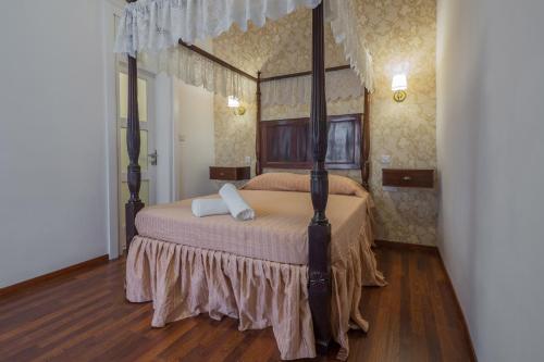 a bedroom with a four poster bed with two pillows at Valletta Suite Drew in Valletta