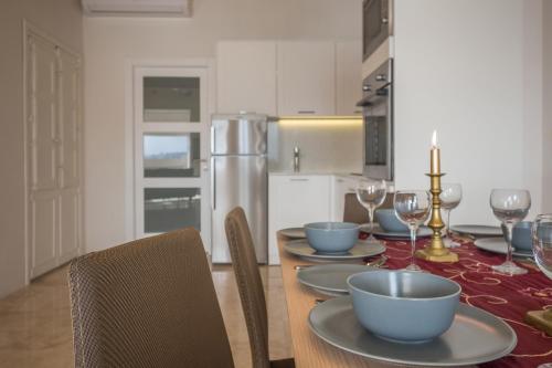 una sala da pranzo con un tavolo con piatti e bicchieri da vino di Valletta Suite Drew a La Valletta
