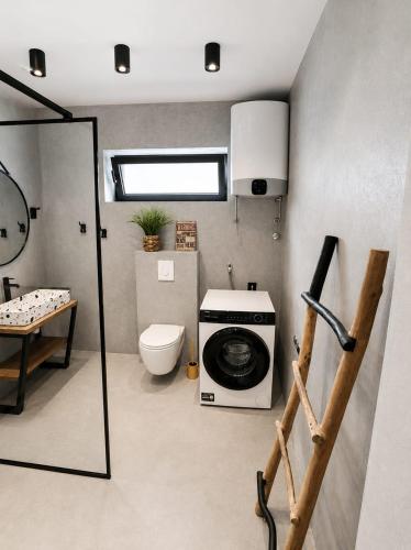 a bathroom with a washing machine and a toilet at Apartment Luka in Tučepi