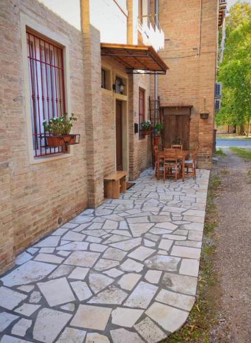 a stone patio with a table and a building at Casa Virginia in Torrenieri