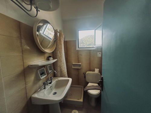 a bathroom with a sink and a toilet and a mirror at Stay for 2 by Alecos Studios in Poros