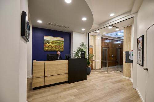 an office lobby with a desk with a painting on the wall at Mantra Adelaide Central in Adelaide