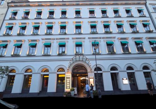 a large white building with people standing in front of it at Wonder - The Luxury Boutique Hotel in Budapest