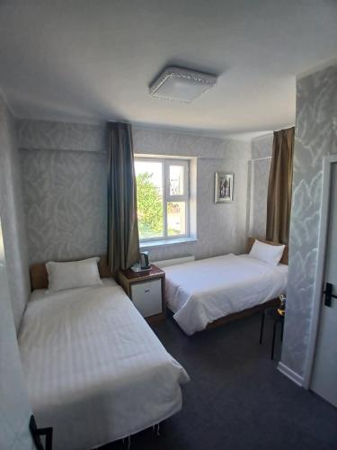 a hotel room with two beds and a window at Gandan Peace Guest House in Ulaanbaatar