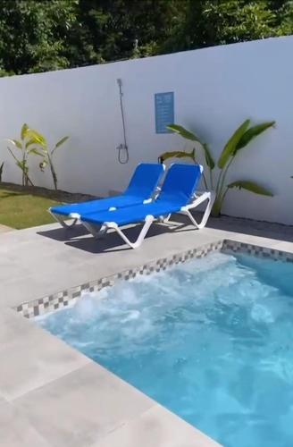 a blue lounge chair next to a swimming pool at Villa La Vida Dulce Private Pool Near Playa Dorada in Puerto Plata