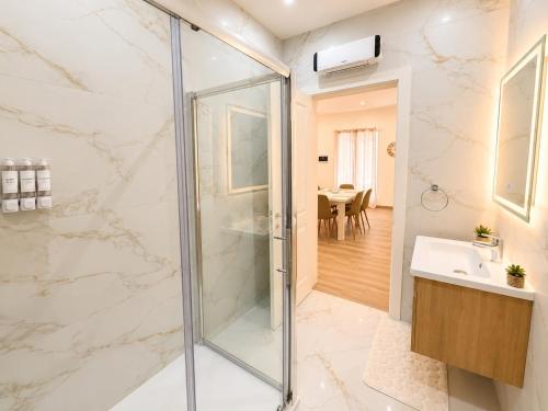 a bathroom with a shower and a sink at Il-Kenn ta Roża Maisonette in Qala