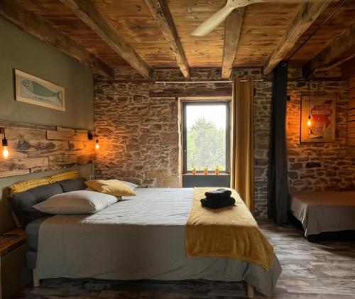 a bedroom with a large bed and a window at Chez Walter et Camille in Saint-Cernin-de-Larche