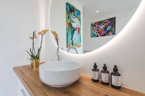 a bathroom with a white bowl and three bottles of wine at La Maison Opaline in Reims