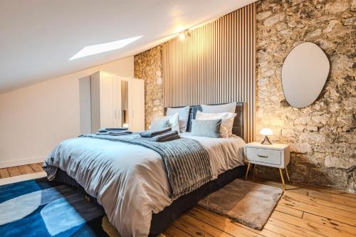a bedroom with a large bed and a mirror at La Maison Opaline in Reims