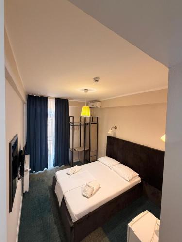 a hotel room with a bed and a television at Hotel Promenada in Mamaia