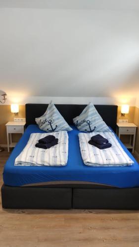 a blue bed with two pillows on top of it at Ferienhaus Happytime in Binz