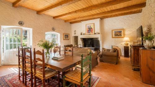 a dining room with a table and a living room at Maison Garesché - Chambres d'hôtes de charme avec table d'hôtes in Nieulle-sur-Seudre