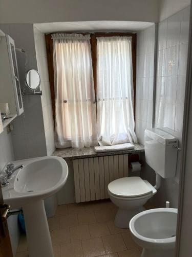 a small bathroom with a toilet and a sink at Albergo Nonaj in Monticello d'Alba