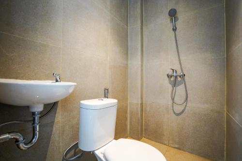 a bathroom with a shower and a toilet and a sink at SANS Stay Arkana Seturan Pakuwon Mall in Yogyakarta