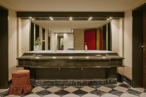 a bathroom with a large mirror and a sink at Locke am Platz Zurich in Zurich
