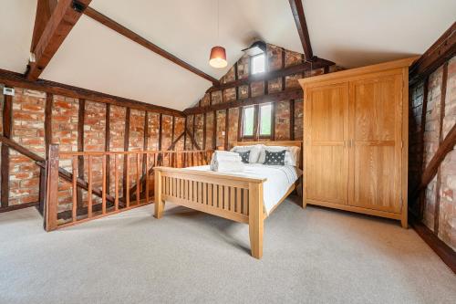 a bedroom with a bed in a room with wooden walls at Barn Conversion Sleeps 2 with Parking in Diss