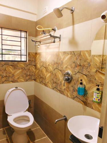 a bathroom with a toilet and a sink at V-Suites in Bangalore