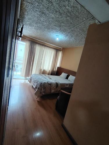 a bedroom with a bed and a large window at Hostal el barranco in Cuenca