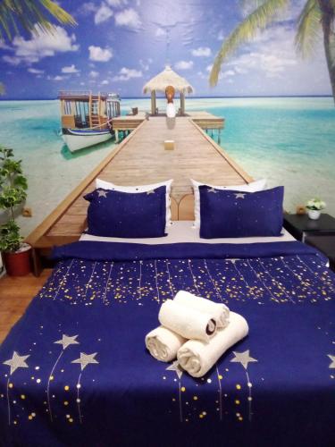 a bed in a room with a painting of the ocean at Комплекс Тракийски стан in Asenovgrad