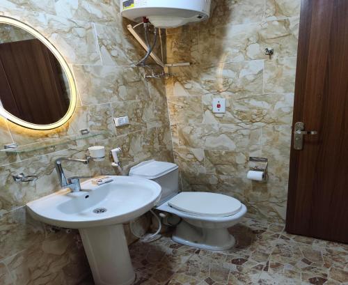 a bathroom with a sink and a toilet and a mirror at Sunset Mirage House in Giza
