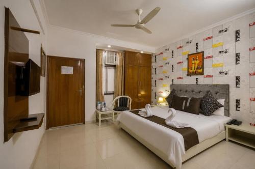 a bedroom with a large bed and a television at Hotel Silver Leaf, Noida in Noida