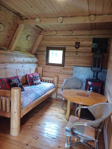 a room with a couch and a table in a cabin at Ethno Houses Uskoci in Uskoci