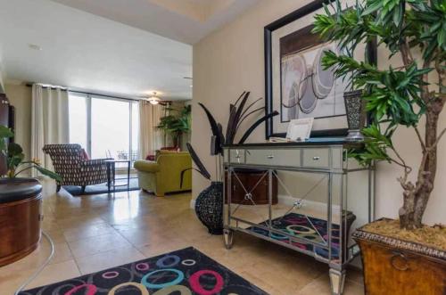 a living room with a table with a plant at Three Bedroom Corner Condo with Gulf View Balcony in Pensacola