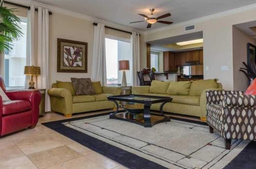 a living room with two couches and a table at Three Bedroom Corner Condo with Gulf View Balcony in Pensacola