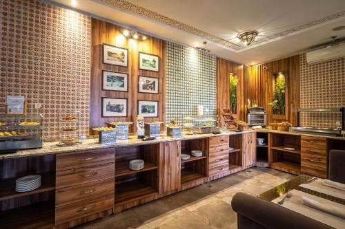 a kitchen with wooden cabinets and a brick wall at Hotel & Ryad Art Place Marrakech in Marrakesh