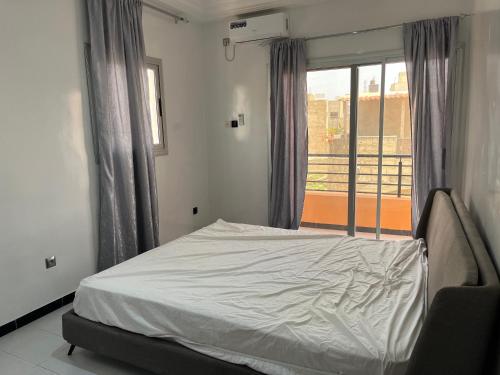 a bedroom with a bed and a window with a view at Appartement confort keur massar in Rufisque