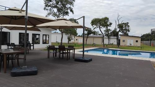 a patio with tables and umbrellas next to a pool at Muzhi Wetu Lodge in Chanamo