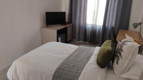 a bedroom with a bed with a tv on a dresser at Muzhi Wetu Lodge in Chanamo