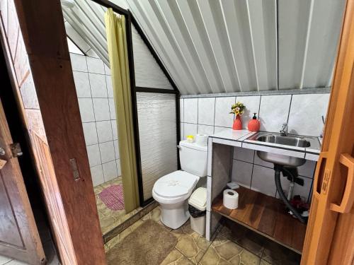 a small bathroom with a toilet and a sink at Cabaña Escondida Rio Celeste in El pilon